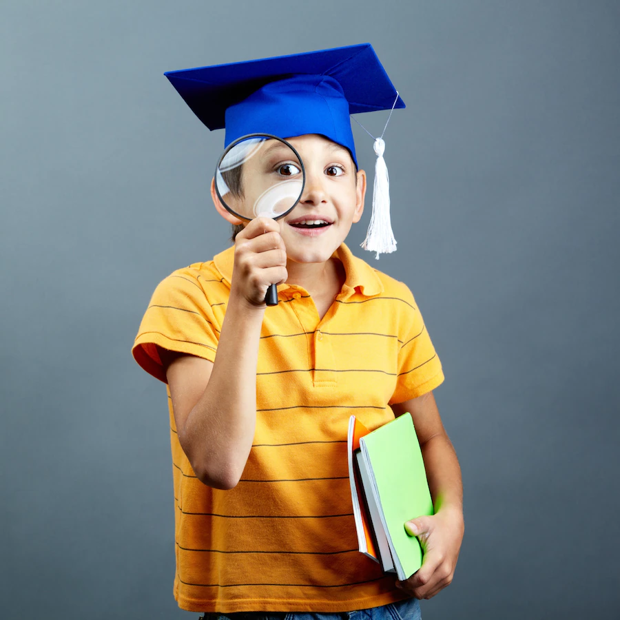 smiling-student-playing-with-his-magnifying-glass_1098-3432